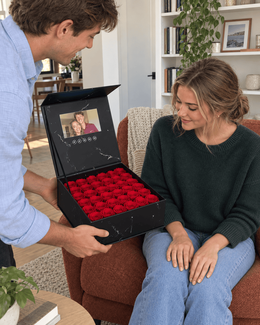 A man giving his partner a rose movie box as she smiles in surprise