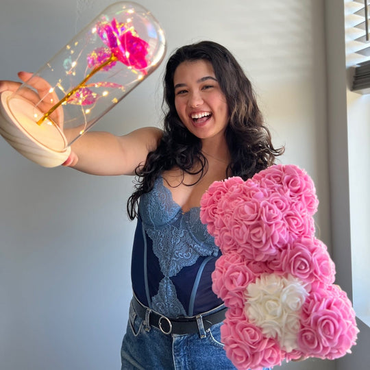 Woman holding up a pink Enchanted Sparkly Rose and a pink Rose Bear